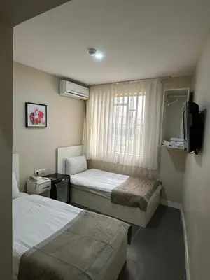 a hotel room with two beds and a television at Rota Star Hotel Beyoğlu in Istanbul