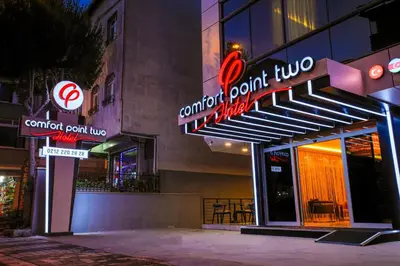 a restaurant with neon signs in front of a building at Comfort Point Two Hotel in Istanbul