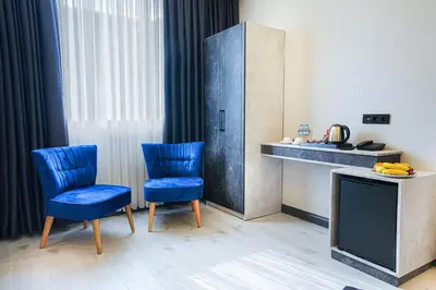 a room with two blue chairs and a television at Comfort Point Two Hotel in Istanbul