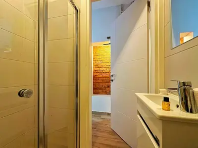 a white bathroom with a shower and a sink at Triplex in Taksim Square with 4 Bedroom in Istanbul