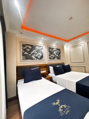 two beds in a room with an orange ceiling at New Fors Hotel in Istanbul