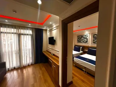 a bedroom with a bed and a desk with a television at New Fors Hotel in Istanbul