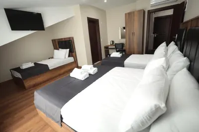 a hotel room with two beds and a television at BZN Airport Hotel in Arnavutköy