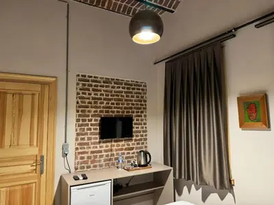 a room with a brick wall with a desk and a television at HanFlats in Istanbul