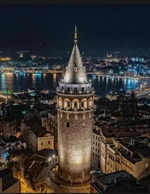 a building with a clock tower at night at La Pazza Suites in Istanbul