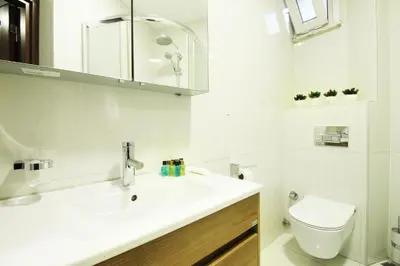 a white bathroom with a sink and a toilet at Excellent Apartments Fatih Serenity in Istanbul