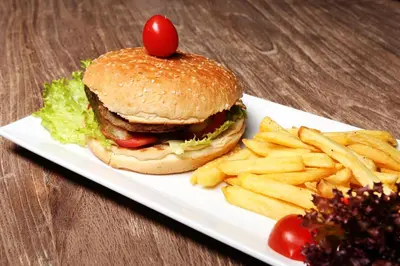 a plate with a hamburger and french fries on a table at Sarissa Hotel in Istanbul