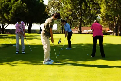 a group of people playing golf on a golf course at Kemer Country Hotel İstanbul in Istanbul
