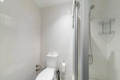 a white bathroom with a toilet and a shower at Nish Suites Atasehir in Istanbul