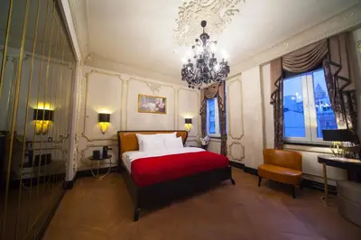 a bedroom with a red bed and a chandelier at Nordstern Hotel Galata in Istanbul