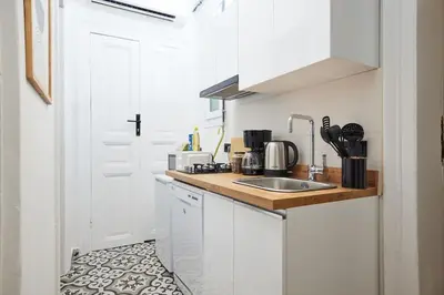 a kitchen with white cabinets and a sink at Charming 2BR AC in Center - Santur D1 in Istanbul