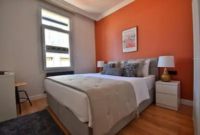 a bedroom with a large bed with an orange wall at Cozy Renovated 3BR near Taksim- Santur D10 in Istanbul