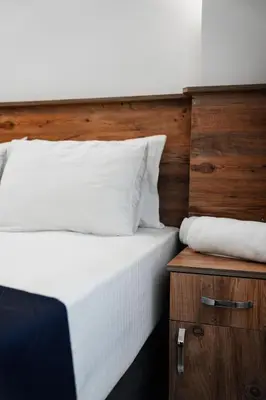 a bed with white sheets and a wooden head board at The balo pera hotel in Istanbul