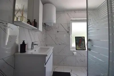 a white bathroom with a sink and a window at Stunning 6BR 4Bath near Tram in Istanbul