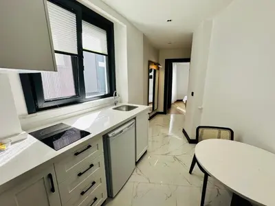 a kitchen with a sink and a table at Rose Point Residence in Istanbul