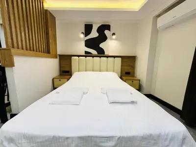 a large white bed with two white towels on it at Rose Point Residence in Istanbul