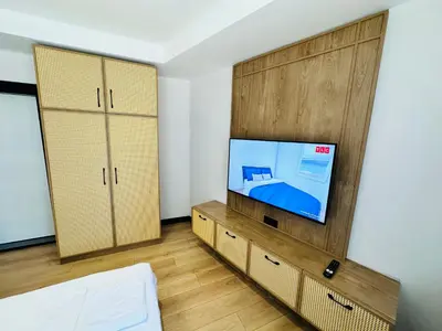 a living room with a tv and wooden cabinets at Rose Point Residence in Istanbul