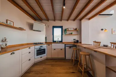 a kitchen with white cabinets and a wooden ceiling at Sapanca İnci Suit in Yanık