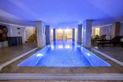 a large swimming pool in a building with blue lighting at Boğaz Manzaralı Havuzlu Lüks Villa in Istanbul