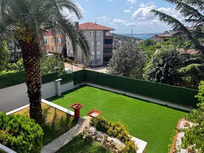 a garden with a green lawn and a palm tree at Boğaz Manzaralı Havuzlu Lüks Villa in Istanbul