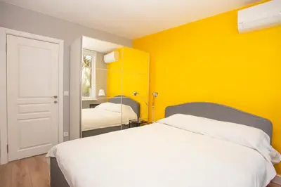 a yellow bedroom with a bed and a mirror at Waterfront Apartments with a Stunning View in Istanbul