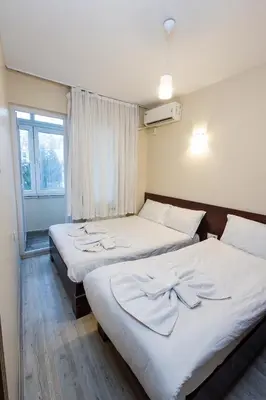 two beds in a room with a window at Marmara Apartments in Istanbul