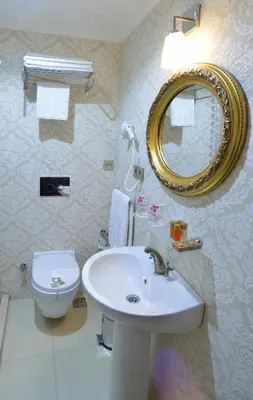 a bathroom with a sink and a toilet and a mirror at By Murat Royal Hotel Galata in Istanbul