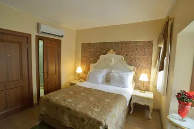 a bedroom with a large bed with two tables and two lamps at By Murat Royal Hotel Galata in Istanbul