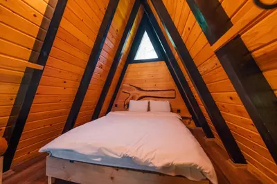 a bed in a wooden room with a window at MC Sapanca Hotel in Sakarya
