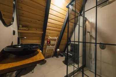 a bathroom with a sink and a wooden wall at MC Sapanca Hotel in Sakarya