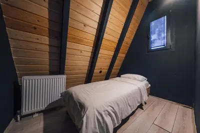a bedroom with a bed in a room with wooden walls at MC Sapanca Hotel in Sakarya