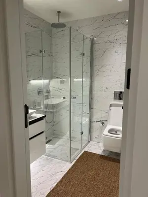 a bathroom with a glass shower and a toilet at Enjoy luxury family apt in Istanbul