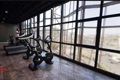 a gym with large windows with a person in the background at Cozy luxury apt in Sinpas queen in Istanbul