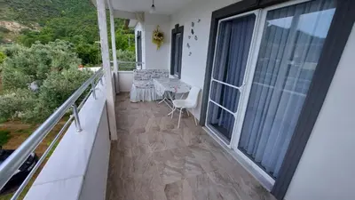 a balcony with a table and chairs on it at Kadıoğlu Pansiyon in Ormanlı