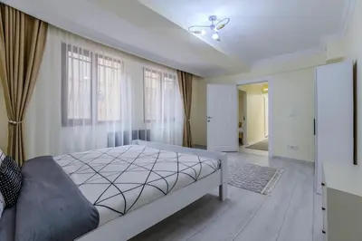 a bedroom with a bed and a couch and windows at Fatih'te yeni 3 odalı Daire No 1 in Istanbul
