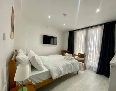 a bedroom with a bed with white sheets and a television at Nostalgia Apartment in Istanbul