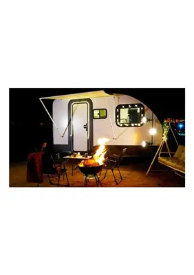 a camper with a table and chairs and a fire at HUZURLU BİR TATİl - CARAVAN SERENITY in Domalı