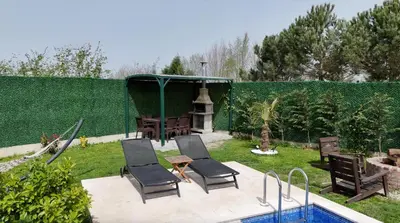 a backyard with a pool and chairs and a gazebo at Bonte Sapanca in Feyziye