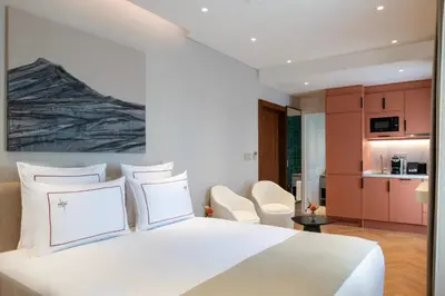 a bedroom with a white bed and a kitchen at Casa Foscolo Hotel, Istanbul, a Member of Design Hotels in Istanbul