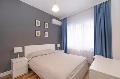 a bedroom with a bed and a window with blue curtains at Trendy Waterfront Apt with a Striking View in Istanbul