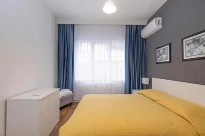 a bedroom with a yellow bed and a window at Trendy Waterfront Apt with a Striking View in Istanbul