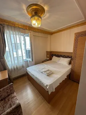 a bedroom with a bed and a chandelier at Delbab PANSİYON in Istanbul
