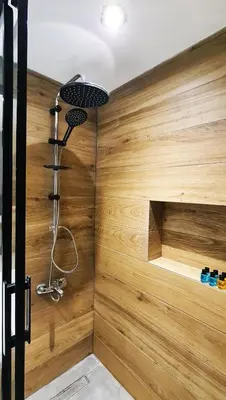 a bathroom with a wooden wall with a shower at Excellent Apartments Fatih Legacy in Istanbul