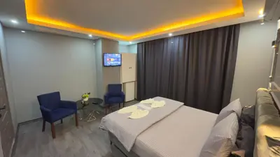 a hotel room with a bed and two chairs and a tv at Cevas Suite Hotel in Istanbul