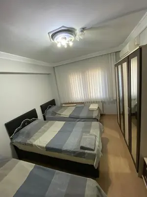 a bedroom with two beds and a chandelier at İsra home 2 in Istanbul