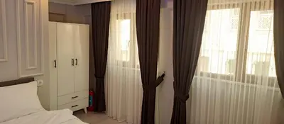 a bedroom with curtains and a bed and a window at Özdemir Apart - Sultanahmet in Istanbul