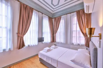 a bedroom with a large bed with windows at Va Mansion in Istanbul