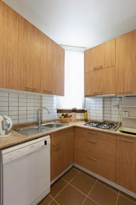 a kitchen with wooden cabinets and a white dishwasher at Bomonti Residence charming flat in Istanbul