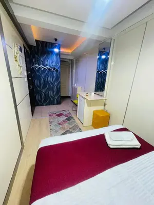 a bedroom with a white bed with a red blanket at Taksim Gold House Hotel in Istanbul