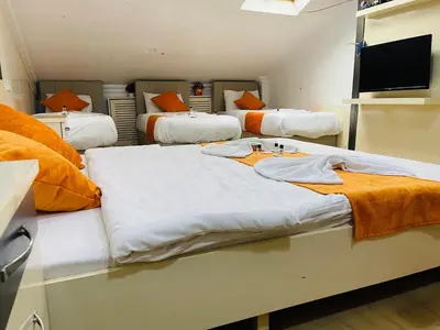 a room with three beds and a flat screen tv at Taksim Gold House Hotel in Istanbul